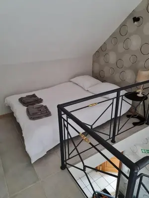 a small bedroom with a bed and a shelf at Casa Kanella Vakantiewoning in Maasmechelen