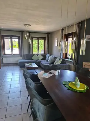 a living room with a table and a couch at Casa Kanella Vakantiewoning in Maasmechelen