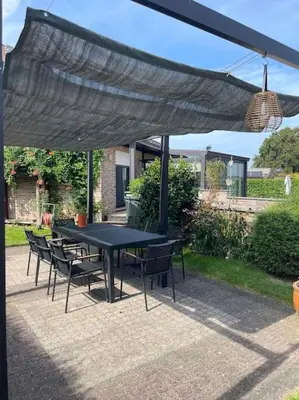 a black table and chairs under a black umbrella at Casa Kanella Vakantiewoning in Maasmechelen