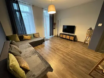 a living room with a couch and a flat screen tv at Au 167 Maison de Village in Seraing