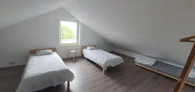 a attic room with two beds and a window at Au 167 Maison de Village in Seraing
