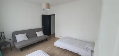 a living room with a couch and a bed at Au 169 La maison du coin in Flémalle-Grande