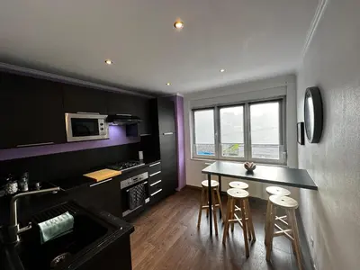 a kitchen with a counter and stools in a room at Au 11811 Bel appartement cosy in Loncin