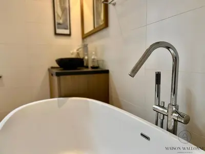 a white bath tub with a faucet in a bathroom at La maison de Maître - Grand Jardin, Face à la Meuse in Hermalle-sous-Argenteau