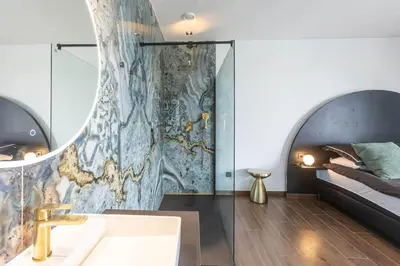 a bathroom with a sink and a bed in a room at le Bellessa Gite de luxe pour 2 personnes in Basse Tribomont