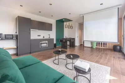 a living room with a green couch and a kitchen at le Bellessa Gite de luxe pour 2 personnes in Basse Tribomont