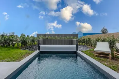 a pool of water with a bench in a yard at le Bellessa Gite de luxe pour 2 personnes in Basse Tribomont