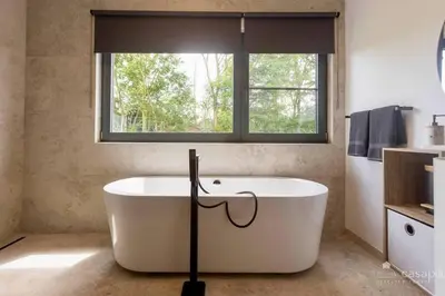 a bath tub in a bathroom with a window at Lodge 4 you gite de luxe pour 4 personnes in Verviers