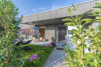 a garden in front of a building with an umbrella at Gite SIWA pour 2 personnes in Verviers