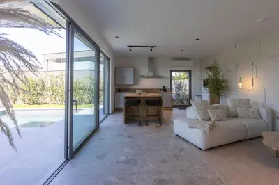 a living room with a white couch and a kitchen at Gite Olea de deux personnes in Basse Tribomont