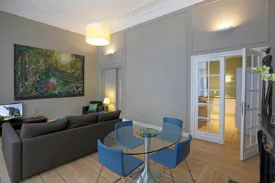 a living room with a couch and a table and chairs at Aparthotel Liège in Liège