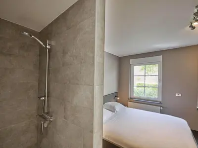 a bedroom with a shower and a bed and a window at Bigaro 1 in Heers