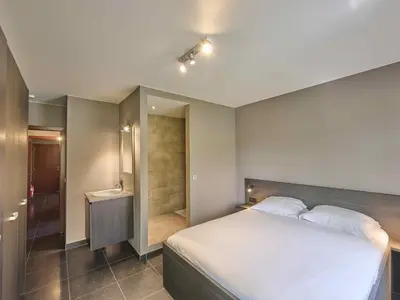 a bedroom with a large bed and a bathroom at Bigaro 1 in Heers