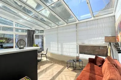 a living room with a couch and a glass ceiling at Vakantiewoning De Merode in Lanaken