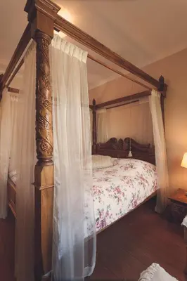 a bedroom with a canopy bed with white curtains at De Brugdraaier - The Bridge Turner in Neerpelt