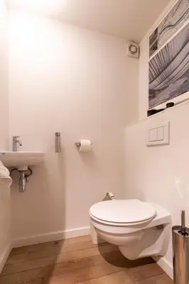 a white bathroom with a toilet and a sink at Louvrex 78 in Liège