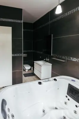 a bathroom with a tub and a toilet and a sink at Hotel Riad Nour in Liège