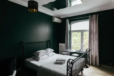 a green bedroom with a bed and a window at Hotel Riad Nour in Liège