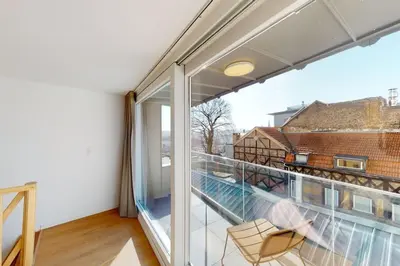 a balcony with a chair and a large window at House W 35 in Liège