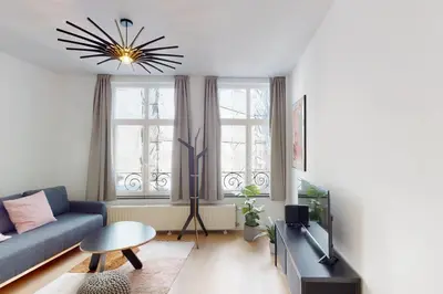 a living room with a blue couch and a tv at House W 35 in Liège