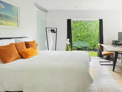 a white bed with orange pillows in a bedroom at 8P 4B Lanaken Retreat: Swimming Pool Jacuzzi and Sauna in Lanaken
