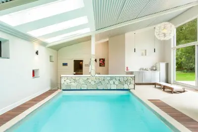 a swimming pool in a house with a skylight at 8P 4B Lanaken Retreat: Swimming Pool Jacuzzi and Sauna in Lanaken
