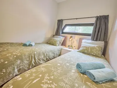 a small bedroom with two beds and a window at De Eekhoorn in Zutendaal
