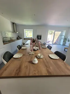 a large wooden table in a living room with chairs at La grange aux anneaux in Beaurieux