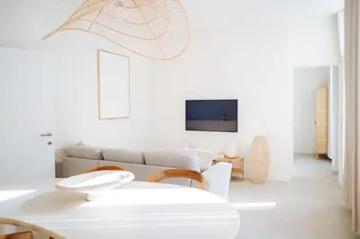 a white living room with a couch and a table at Sweet Coffee Stay in Hasselt