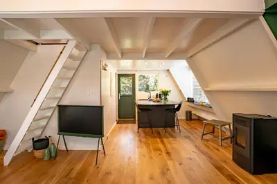 an attic room with a desk and a tv at Boshuisje Rekem - Ignis in Lanaken