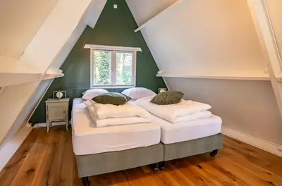 two beds in a attic bedroom with green walls at Boshuisje Rekem - Ignis in Lanaken