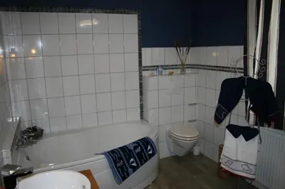 a bathroom with a white tub and a toilet at B&B Ferme du Petit Breuil in Verviers
