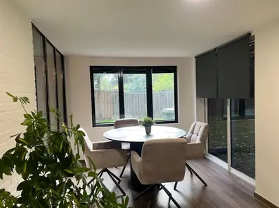 a dining room with a white table and chairs at Etwee Vakantiehuis in Lanaken