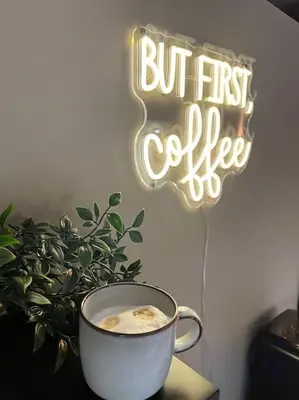 a cup of coffee sitting on a table next to a sign at Etwee Vakantiehuis in Lanaken