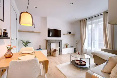 a living room with a table and a fireplace at - Le Cocoune - Cosy & Cute Flat in Liège