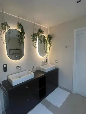 a bathroom with two sinks and two mirrors at Aurelia Glamping en B&B in Lommel