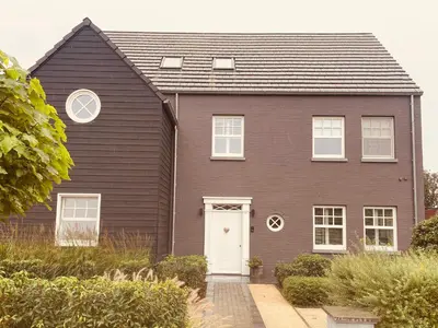 a brown house with a white door at Aurelia Glamping en B&B in Lommel
