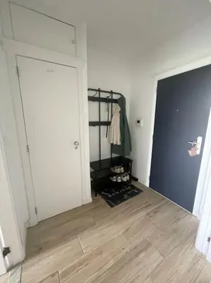 a room with a large white door and a wooden floor at Appartement panoramique plein sud Liège in Liège