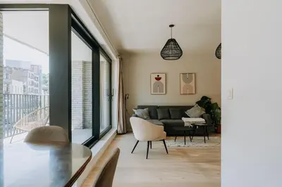 a living room with a couch and a table at 2 bedroom apartment and private parking in Liège center in Liège