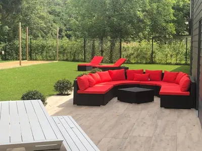 a red couch with red pillows on a patio at Riverside house in Trooz