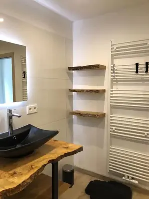 a bathroom with a black sink and a mirror at Riverside house in Trooz