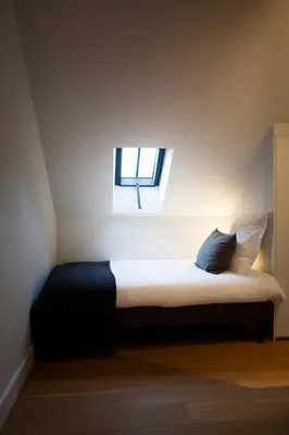 a small bedroom with a bed with a window at O-Lit in Paal