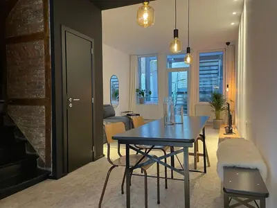 a dining room with a blue table and a living room at 2 bedroom duplex in the historic heart of Liège in Liège