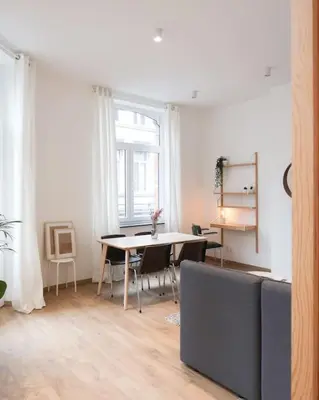 a living room with a table and a window at 1 bedroom apartment in Liège center - 1st floor in Liège