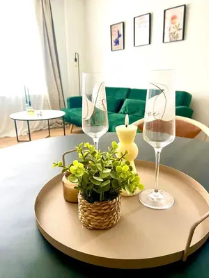 a table with two wine glasses and a plant on it at Le cozy escape in Herstal