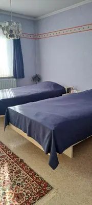 two beds with blue sheets in a bedroom at A home away from home in Oudsbergen
