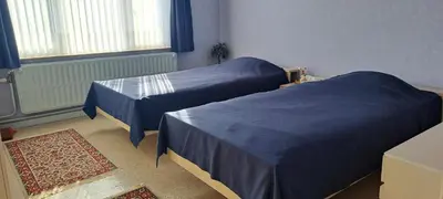 two beds in a room with blue covers on them at A home away from home in Oudsbergen
