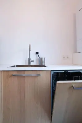 a kitchen with a sink and wooden cabinets at 1 bedroom apartment in Liège center - 2nd floor in Liège