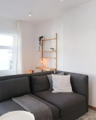 a black couch in a living room with a window at 1 bedroom apartment in Liège center - 2nd floor in Liège