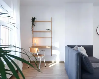 a living room with a blue couch and a desk at 1 bedroom apartment in Liège center - 3rd floor in Liège